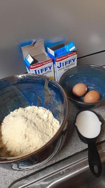 Mise en place for Jiffy cornbread mixed with two boxes of Jiffy two eggs two-thirds cup milk and the Jiffy mix in a bowl