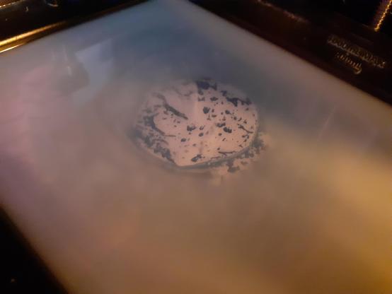A pearlescent bath of 3D printing resin, with a clear blue/white mottled circle near the centre.