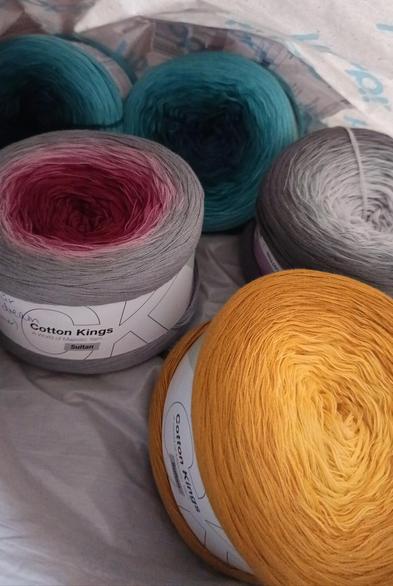 Verschiedenfarbige Baumwoll-Knäuel in einer Tüte.