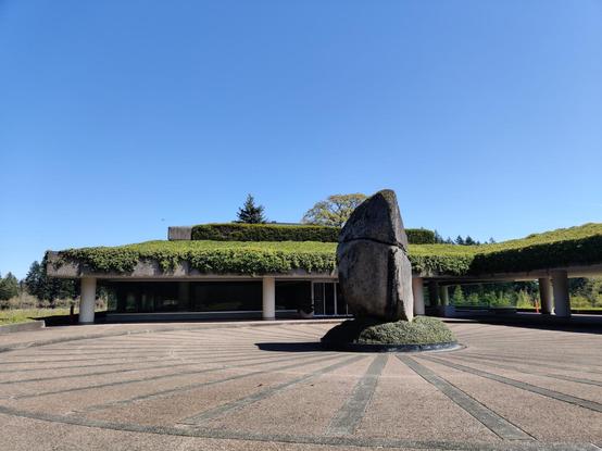 A photograph of the Wayerhauser building in Federal Way Washington. Ivy hangs from the roof behind a monolithic... er.. monolith.