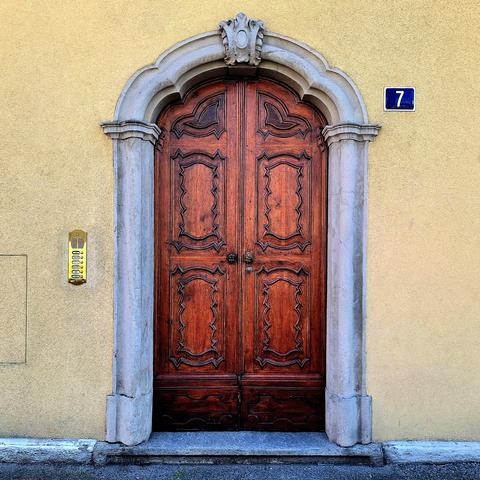 Picture of an ornate wooden door with a stone frame.