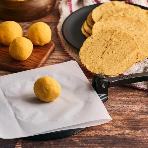 Tortillapresse af støbejern med dejkugle, før presning
