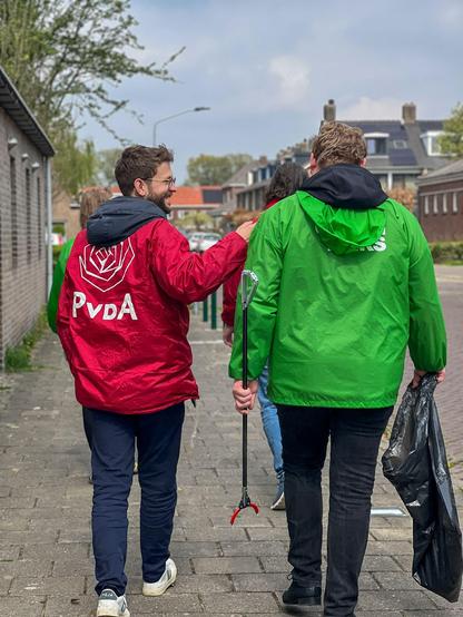 Foto van ons op straat met jasjes van GroenLinks en PvdA om in gesprek te gaan met inwoners uit de wijk Boeimeer in Breda.