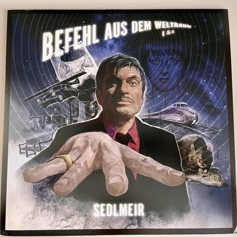 Ein farbenfrohes Plakat im Retrostil, das einen Mann mit Schnurrbart zeigt, der seine Hand nach vorne streckt. Im Hintergrund sind verschiedene surreale Elemente wie Autos, Züge und das Gesicht einer Frau zu sehen, alles vor dem Hintergrund eines kosmischen Themas.