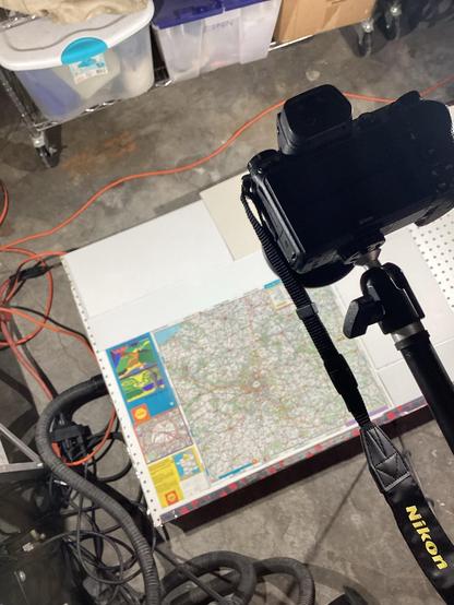 A document scanning setup in a basement —an illuminated map on a low platform, with a camera on a boom overhead