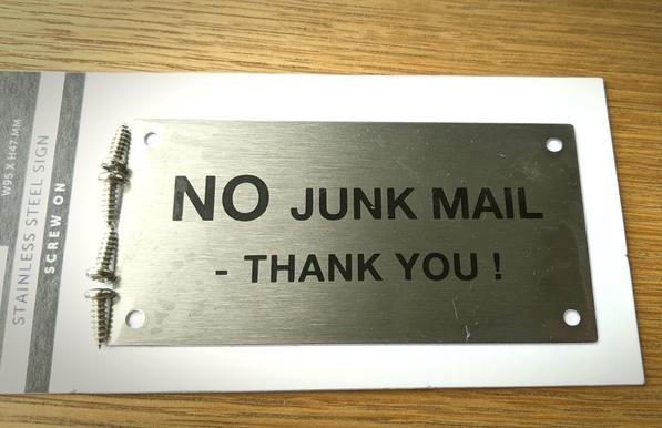 Small metal sign with text: NO junk mail - Thank you