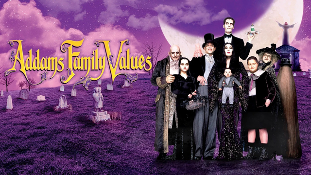 Christopher Lloyd as Uncle Fester, Christina Ricci as Wednesday, Christopher Hart as Thing, Raul Julia as Gomez, Anjelica Huston as Morticia, Carel Struycken as Lurch, Jimmy Workman as Pugsley, and Carol Kane as Granny. They, as the Addamses, stand in a graveyard next to the text "Addams Family Values".