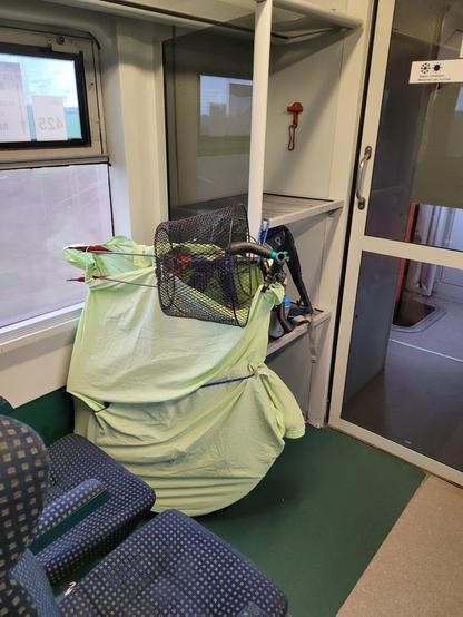 Partly disassembled bicycle between seats and a small luggage shelf.