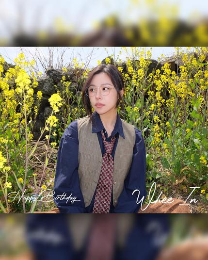 happy birthday card for wheein. photo shows her surrounded by yellow flowers. she is wearing a loose tie & glasses.