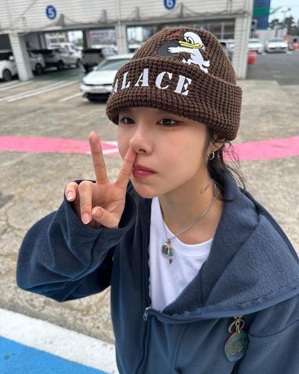photo of wheein wearing a beanie and a hoodie, showing ✌️.