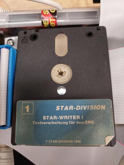 Man sieht eine 3 Zoll Diskette für einen Amstrad / Schneider CPC. Auf dem Label der Diskette steht "Star-Division", "Star-Writer I", "Textverarbeitung für den CPC", "(c) Star-Division 1986".