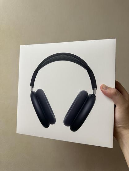 Hand holding AirPods Max (Midnight) box