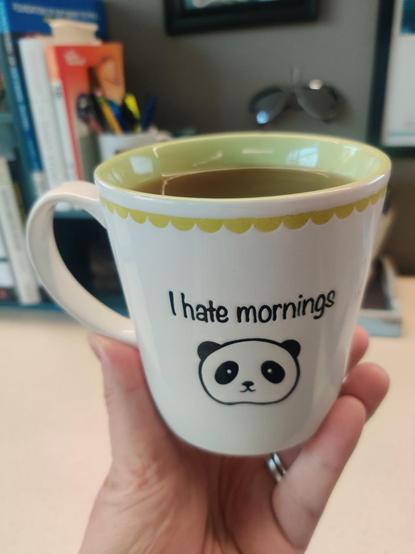 A mug of tea, white with a simply illustrated panda. Text reads "I hate mornings."