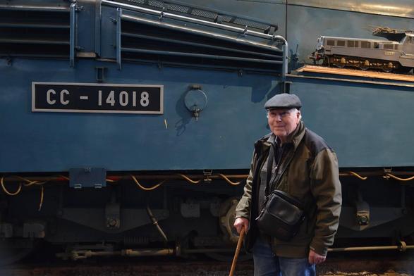 Un cheminot à la retraite pose devant sa machine, une CC 14018, à la Cité du Train de Mulhouse