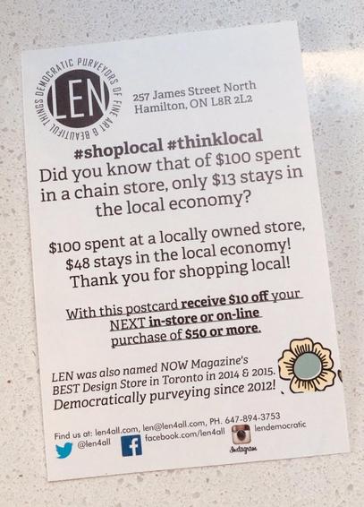A promotional postcard for LEN, a local store in Hamilton, Ontario, encouraging shopping local. It highlights that only $13 from $100 spent at a chain store stays local, compared to $48 spent at a local store.