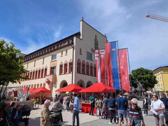 Mairie de Vaduz un samedi de Pâques avec un marché de spécialités locales et des passants qui font la queue au stand de saucisses.