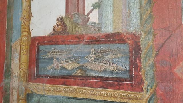 Photo of a detail of a fresco at Pompeii with four Roman or Greek galleys manoeuvring