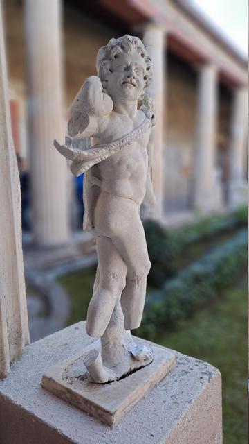 Photo of a Pompeii Roman villa marble statuette of a boy figure, possibly Pan or a woodland fairy sort of figure as there is a leafy strap across his chest