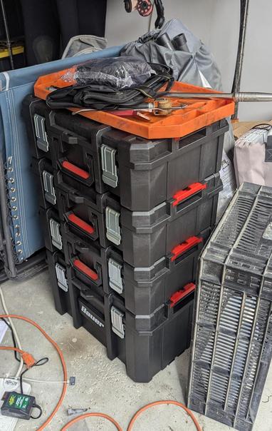 A group of modular toolboxes in a dirty garage.