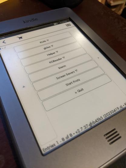 Kindle e-reader with the Kindle Unified App Launcher (KUAL) menu on the screen.