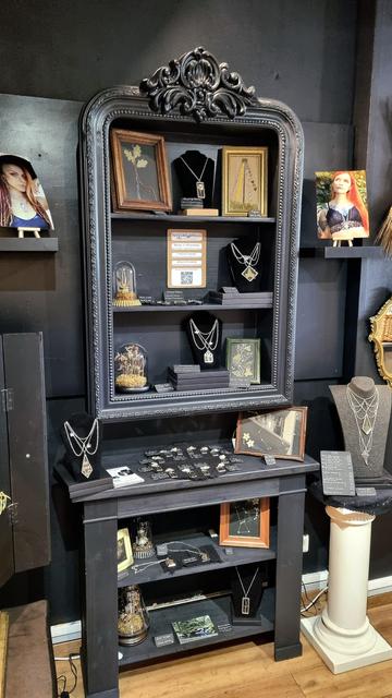English Black furniture with jewelry and decor items on it.
Français Des meubles noirs avec des bijoux et objets de décoration exposés.