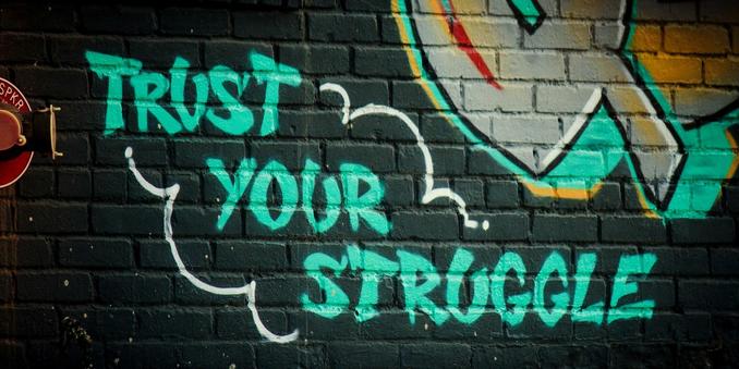 Graffiti that says 'trust your struggle.'