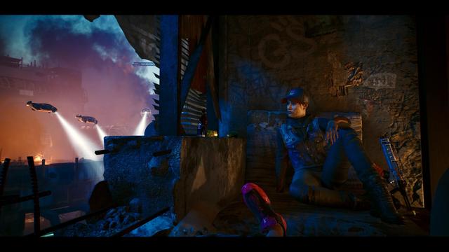 A character sits in a dimly lit, gritty environment, with futuristic flying vehicles visible in the background. The scene features elements of urban decay, colorful lighting, and a variety of objects, including a bottle and some fruit on a surface nearby.