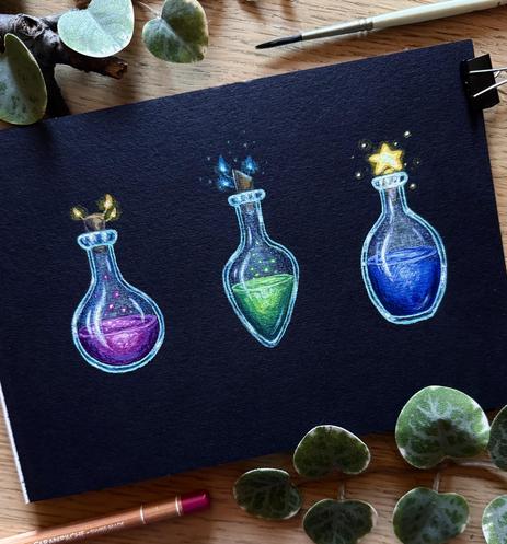 A photo of a black paper pad placed on a desk and surrounded by a coloured pencil, paint brushes, leaves, and branches for decoration. The paper features three little paintings of magic potions: the left one is a dark pink liquid in a round bottle with tiny glowing yellow mushrooms growing out of the cork; the middle one is a toxic green liquid in a rounded diamond-shaped bottle with tiny glowing blue mushrooms growing out of the cork; the right one is a blue liquid in an oval bottle, the cap a glowing yellow star.
