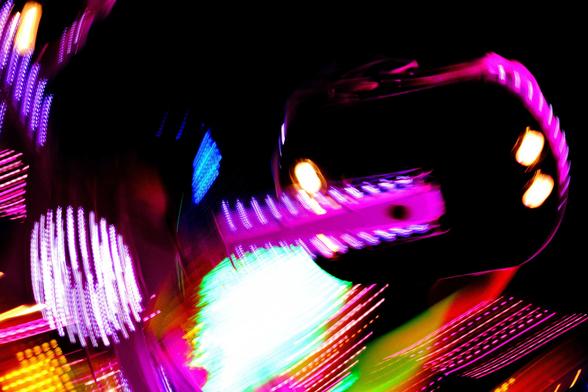 Slow shot of an attraction moving with led lights living traces