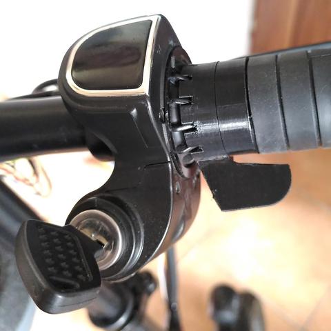 Část řidítek skládacího elektrokola se zapínacím klíčkem. Otočný plyn byl zkrácený a je nahrazený páčkou z 3D tisku pro ovládání palcem.