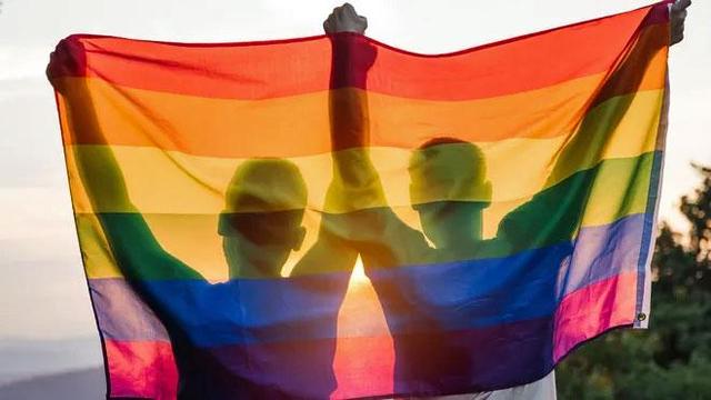 Two people holding rainbow flag
