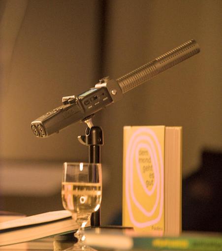 Microphone, book and wine standing for the term "#literaturepodcast"