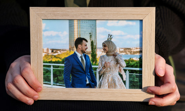 Noor Abdalla holds a portrait, on 12 March, of her and Mahmoud Khalil on their wedding day. Photograph: Caitlin Ochs/Reuters
