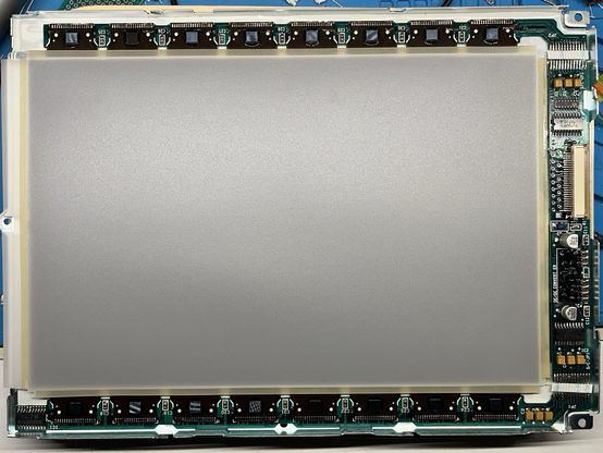 Top down photo of the Powerbook 145 display with removed backlight showing the LCD under its diffuser and the PCB with new capacitors in place