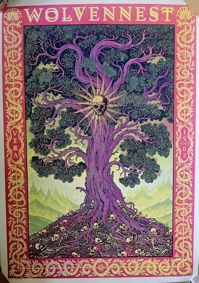 A vibrant, surreal illustration featuring a large, gnarled tree with purple bark and twisting branches. At the center of the tree, where the trunk meets the canopy, is a glowing human skull radiating golden beams of light. The tree's roots are entangled with human skeletons and skulls, creating a haunting scene. The background shows greenish mountains under a pale yellow sky. The image is bordered in red with intricate gold patterns of vines and leaves. At the top, the word “WOLVENNEST” is prominently displayed, with “VERA” and “1502” written vertically on the left and right sides respectively.