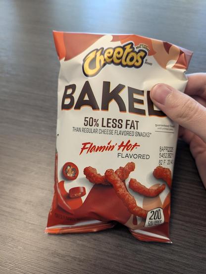A single-serving bag of Flamin' Hot Baked Cheetos. 50% less fat than regular cheese flavored snacks and best by April 8, 2025.