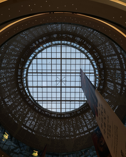 A circular roof ends in a a big window pointing towards the sky. A banner hangs down