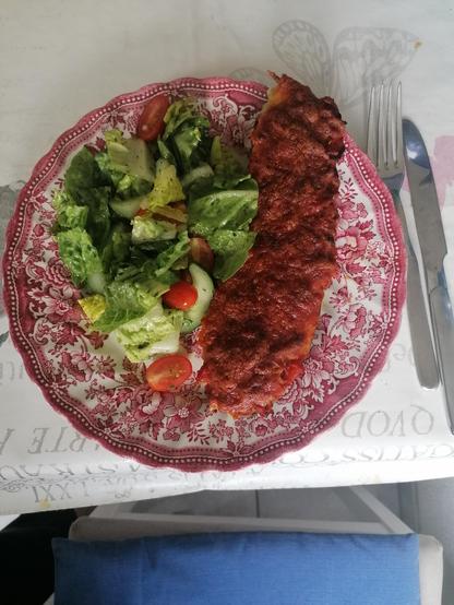 Gefüllte Zucchini auf Teller mit Salat.