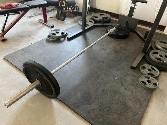 Weighted bar in a landmine attachment on rubber flooring