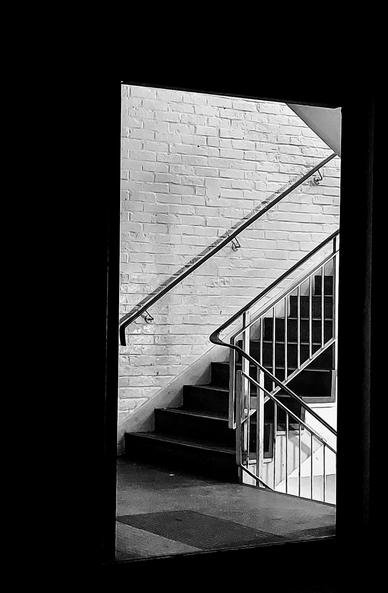 .. night monochrome shot of open doorway [so "door" is an "absent presence"]. Through the "door" there's an artificially lit staircase of the type ya find in multi-platform carparks [which is what this is] .. take it as it resonates ❗️🙏