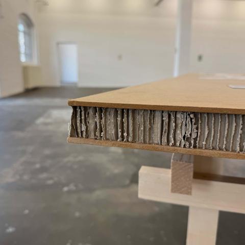 Close-up photograph of a table corner in a gallery space.