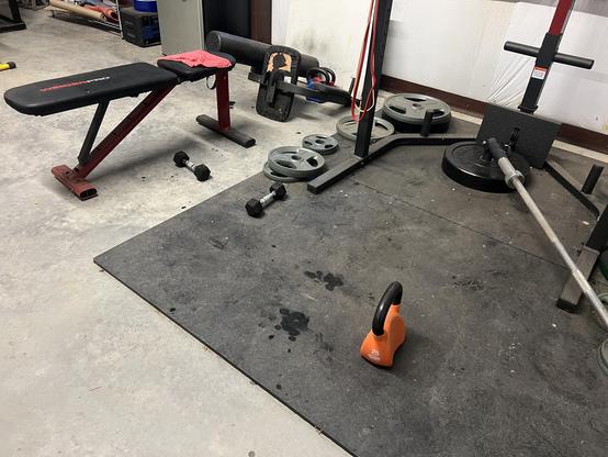 A kettle bell and weights on rubber flooring