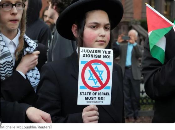 A protester with sign saying "Judaism yes, zionism no"