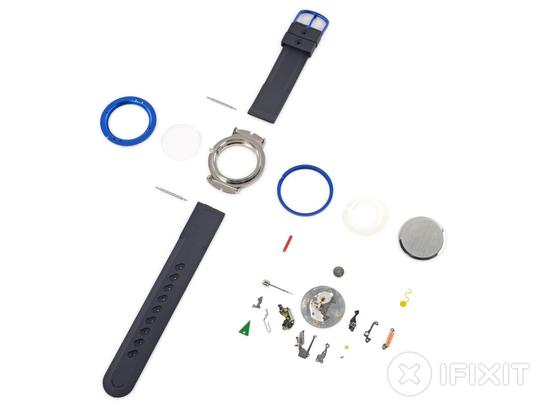 iFixit teardown layout shot of Apple's analog watch from 1995. Every component of the watch, including the bands, body, glass, and all internal machinery, are assorted in a rough grid.