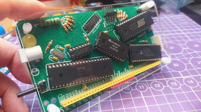 My fully assembled RC2014 Mini II Picasso limited edition kit fully assembled and in my hand. The PCB is populated with lots of chips but everything is at odd weird angles and the whole board looks pretty abstract.