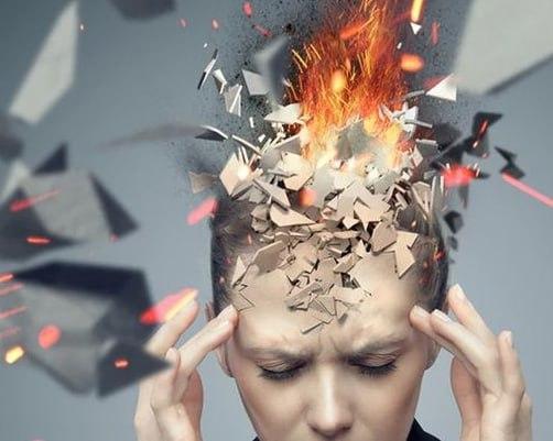 Una persona tocándose la cabeza en señal de dolor de cabeza intenso, mientras se simula que el cráneo le explota por la cantidad de contenidos e información que consume...
