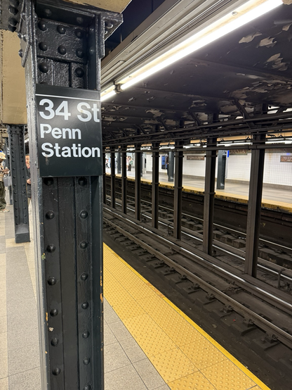 Cast iron pillars in the ny subway, with sign ”34 St Penn Station“