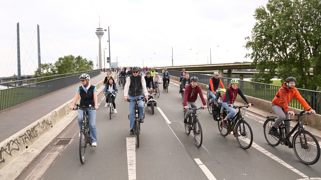 Foto von der Sternfahrt in NRW 2024: Zahlreiche Menschen fahren mit dem Fahrrad über eine für den Autoverkehr gesperrte Brücke in Düsseldorf. 