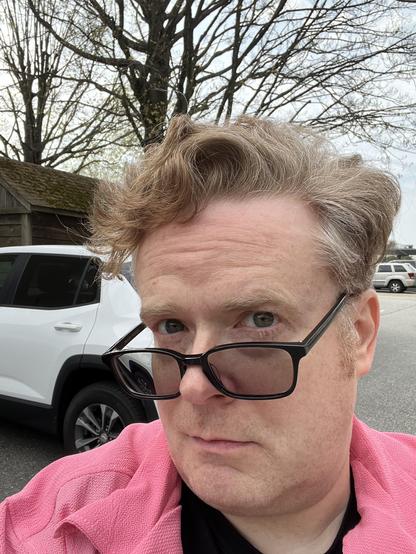 Bill studies his wavy hair critically in a selfie flanked from behind by a tree not yet blooming for spring.