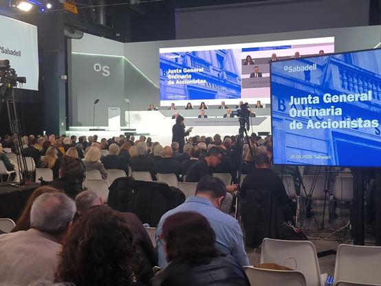 Activista de la campaña Banca Armada participando en la Junta de Accionistas del Banco Sabadell para denunciar sus inversiones en la industria del armamento